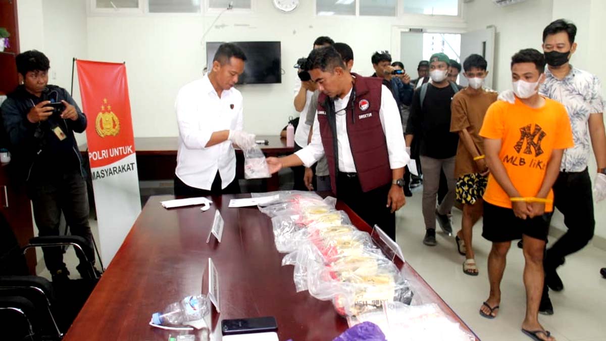 Direktur Reserse Narkoba Polda Sulteng, Kombes Pol Pribadi Sembiring (berbaju putih), memperlihatkan barang bukti narkotika jenis sabu-sabu dan pil ekstasi hasil pengungkapan kasus di Kota Palu. Dua kurir narkoba yang ditangkap tampak digiring dalam konferensi pers di Mapolda Sulteng, Senin (22/9/2025). Foto: Humas Polda Sulteng