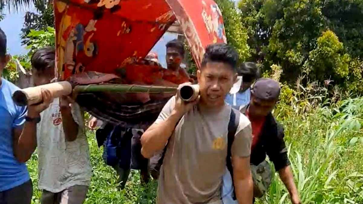 Bripka Abd Harik bersama warga Desa Bambasiang memikul seorang pasien menggunakan usungan sederhana menembus jalur terjal pedalaman Palasa, Kabupaten Parigi Moutong, Senin (22/9/2025). Foto: Humas Polres Parimo