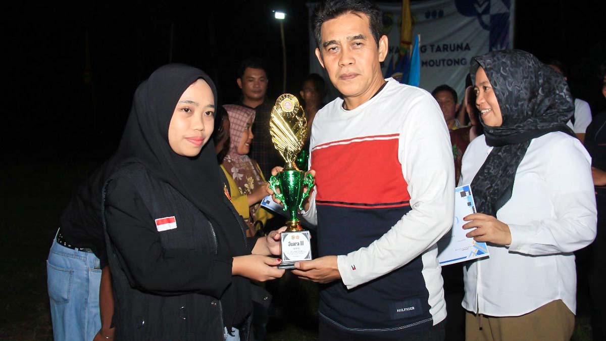 Bupati Parigi Moutong menyerahkan piala kepada salah satu peserta lomba dalam rangkaian Bulan Bakti Karang Taruna tingkat Kabupaten Parimo 2025 di Desa Sidoan Barat, Selasa (30/9/2025). Foto: Diskominfo Parigi Moutong