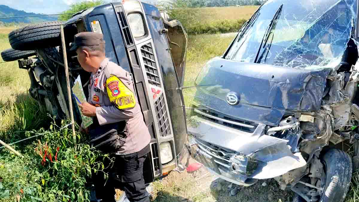 Petugas kepolisian melakukan olah tempat kejadian perkara (TKP) di lokasi tabrakan dua mobil pick up di Desa Suli Indah, Kecamatan Balinggi, Kabupaten Parigi Moutong, Senin (13/10/2025). Satu kendaraan terguling ke area persawahan akibat benturan keras. (Foto: Humas Polres Parimo/Konteks Sulawesi)