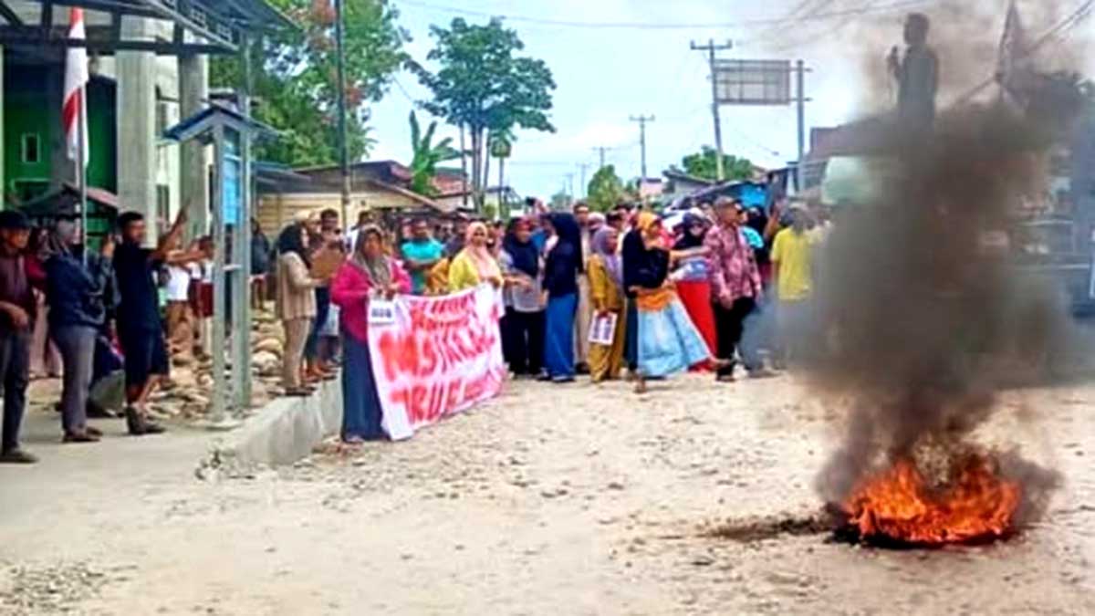 Ratusan warga Desa Torue membentangkan spanduk dan membakar ban di depan Kantor Desa Torue, Kecamatan Torue, Kabupaten Parigi Moutong, Senin (10/11/2025). Aksi ini sebagai bentuk protes dan desakan agar Kepala Desa Kalman M. Andi Mahmud mundur dari jabatannya. Foto: Ist
