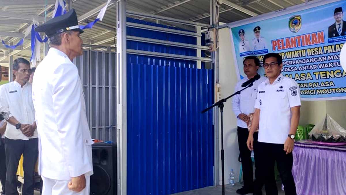 Keterangan Foto: Bupati Parigi Moutong berdiri di depan mimbar saat memimpin prosesi pelantikan Kepala Desa Palasa Tengah sebagai pejabat antar waktu, yang digelar di Desa Ogomolos, Kecamatan Mepanga. Terlihat kades yang dilantik mengenakan setelan putih lengkap, sementara para pejabat daerah menyaksikan prosesi tersebut. Foto: Tommy Noho