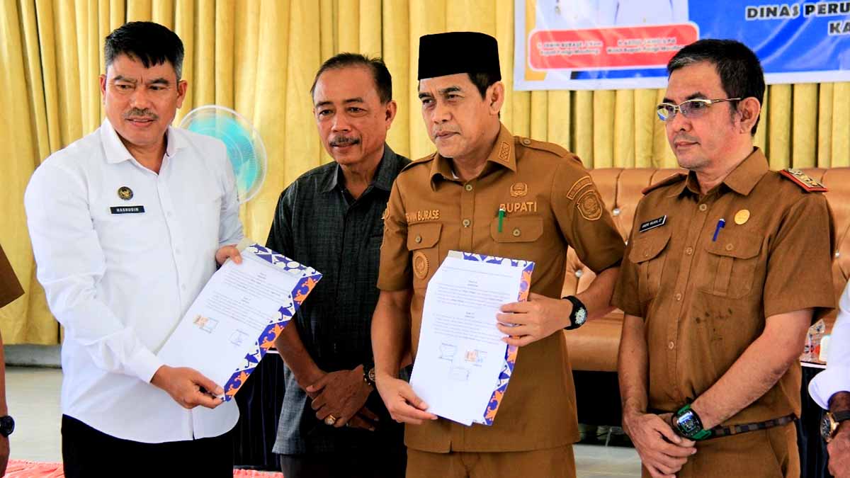 Bupati Parigi Moutong Erwin Burase, dan perwakilan Balai Pemasyarakatan Kelas I Palu memperlihatkan dokumen nota kesepakatan usai penandatanganan kerja sama pada kegiatan penyerahan Bantuan Perumahan Pascabencana Torue dan Bantuan Rumah Swadaya di Kantor Camat Torue, Selasa (16/12/2025). Foto: Diskominfo
