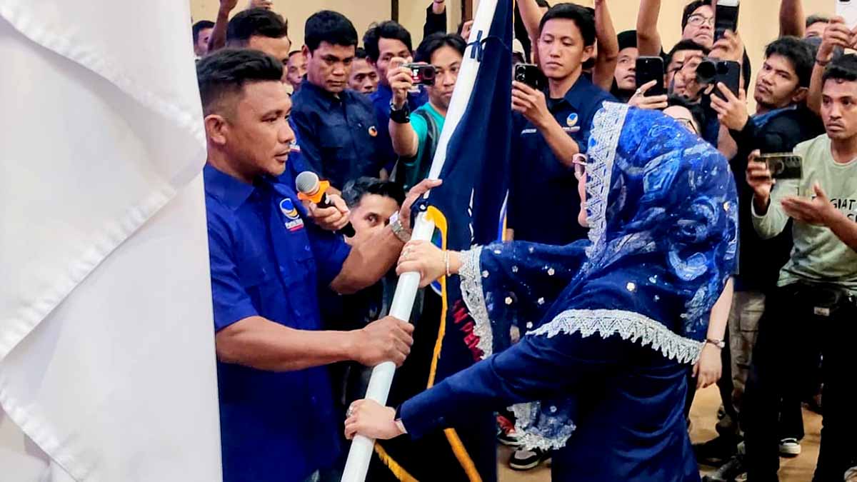 Keterangan Foto: Ketua DPW Partai NasDem Sulawesi Tengah, Nilam Sari Lawira, menyerahkan bendera pataka kepada perwakilan pengurus DPC untuk dikibarkan di seluruh kecamatan saat pelantikan DPC NasDem se-Kabupaten Parigi Moutong di Auditorium Kantor Bupati Parigi Moutong, Sulawesi Tengah, Rabu (24/12/2025). Foto: Tommy Noho