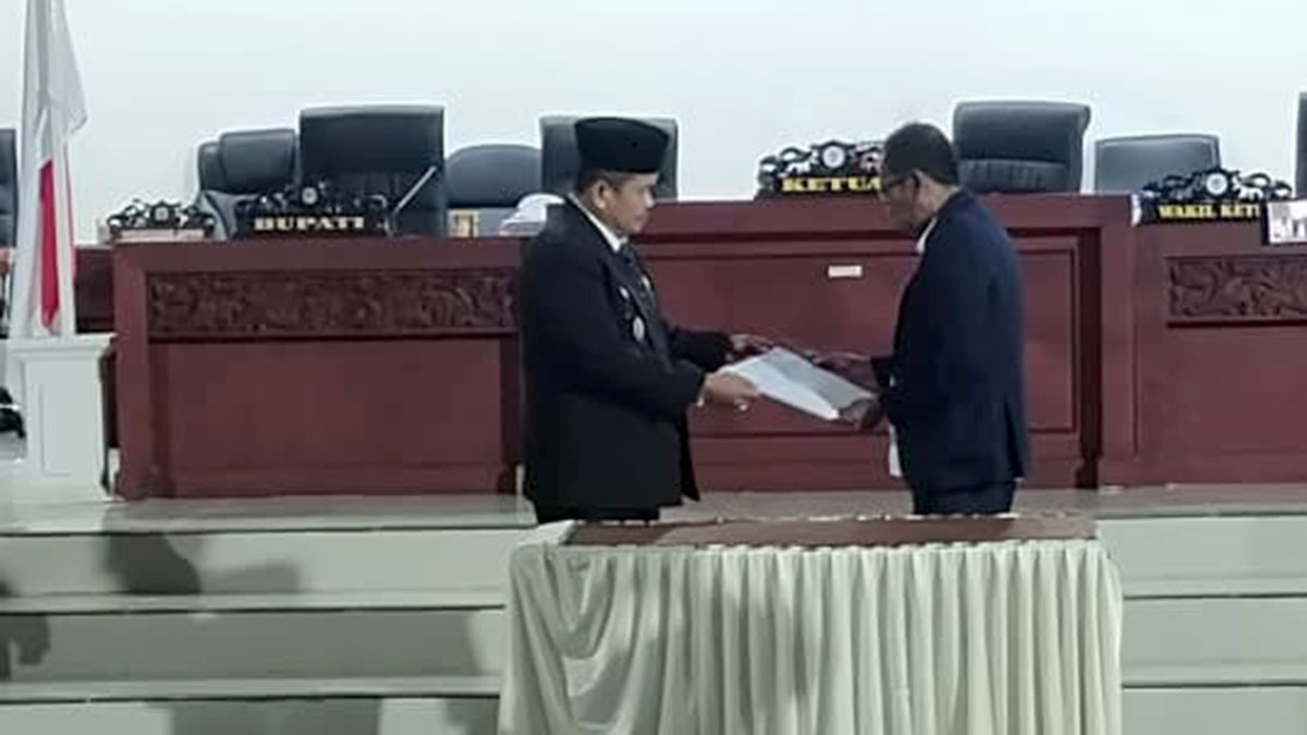 Wakil Ketua I DPRD Kabupaten Parigi Moutong menyerahkan dokumen laporan Badan Anggaran kepada Wakil Bupati Abdul Sahid selaku eksekutif dalam rapat paripurna DPRD Parigi Moutong terkait penyesuaian hasil evaluasi Gubernur Sulawesi Tengah atas Rancangan Peraturan Daerah APBD Tahun Anggaran 2026, di ruang sidang utama DPRD, Senin (12/1/2026). Foto: Tommy Noho